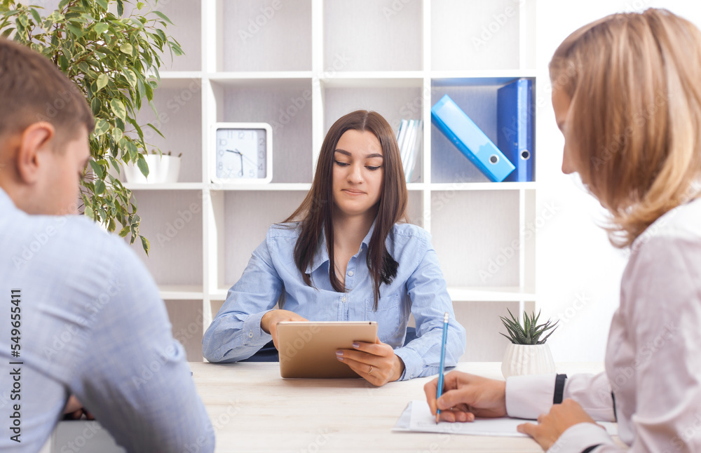 Fototapeta premium Attractive businesswoman, teacher or mentor coach speaking to young people, young woman teaching audience at training seminar, female business leader speaker talking at meeting