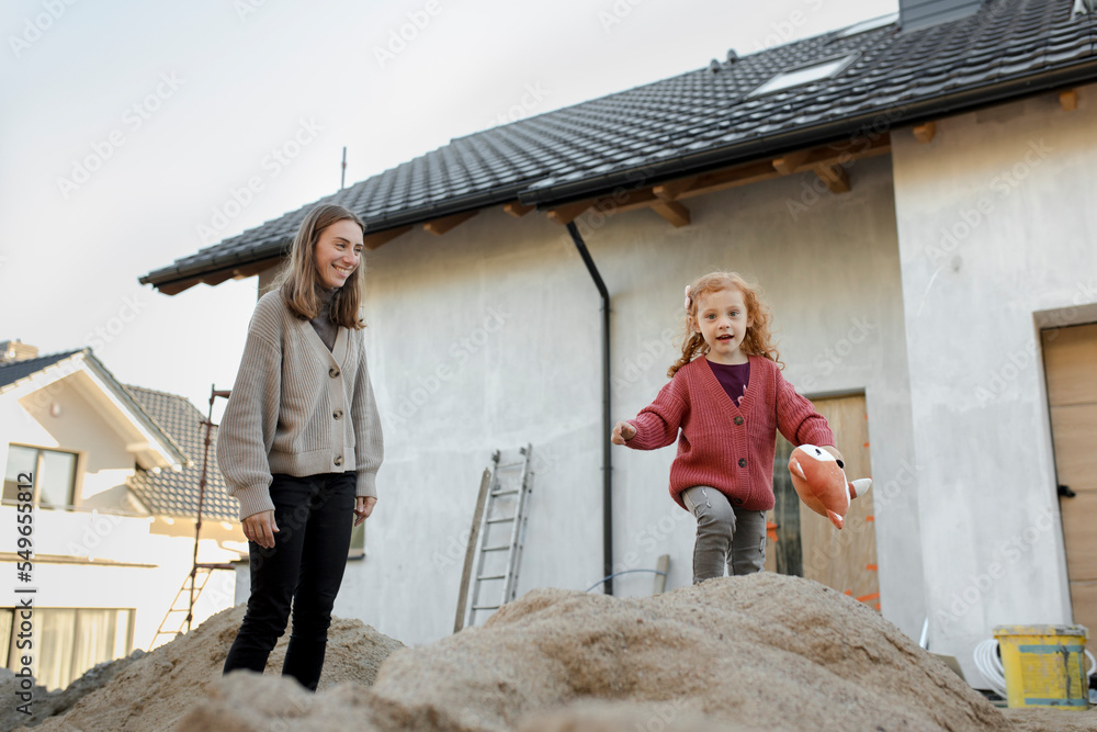 Happy mother playing with daughter outside house Happy mother playing with daughter outside house