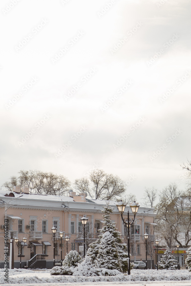 Beautiful town Izmail on south of Ukraine, winter landscape with buildings, trees, street lamps covered with snow and cloudy sky