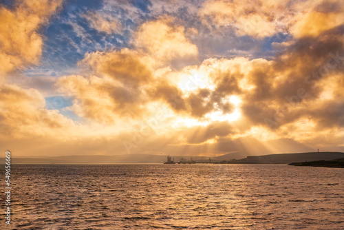 UK, Scotland, Dramatic sunset over Sullom Voe with oil terminal and gas plant in background