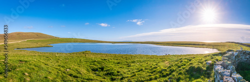 UK, Scotland, Panoramic view of sun shining over Loch of Huxter in summer photo