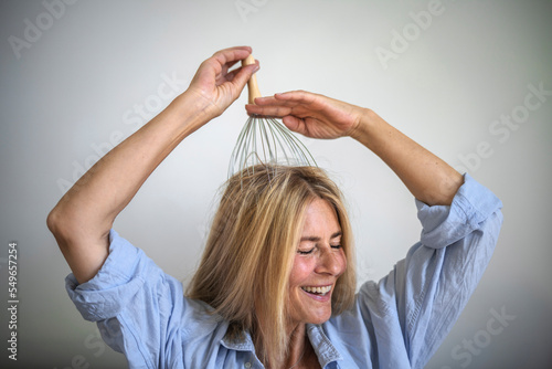 Happy woman enjoying scalp massage through massager at home photo