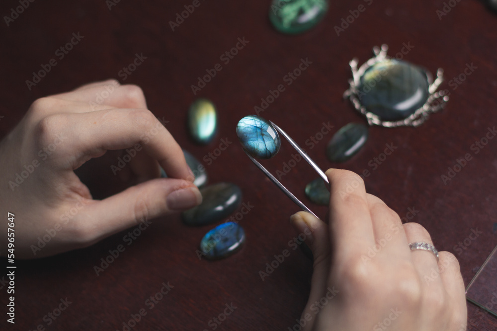 Close up labradorite concept photo. Woman at work. Side view photography with professional instrument on background. High quality picture for wallpaper, travel blog, magazine, article Close up labradorite concept photo. Woman at work. Side view photography with professional instrument on background. High quality picture for wallpaper, travel blog, magazine, article