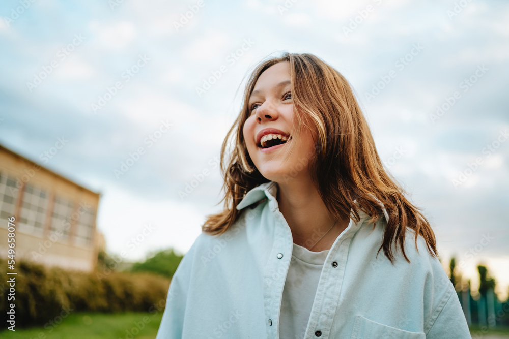 Cheerful teenage girl with blond hair wearing denim shirt Cheerful teenage girl with blond hair wearing denim shirt