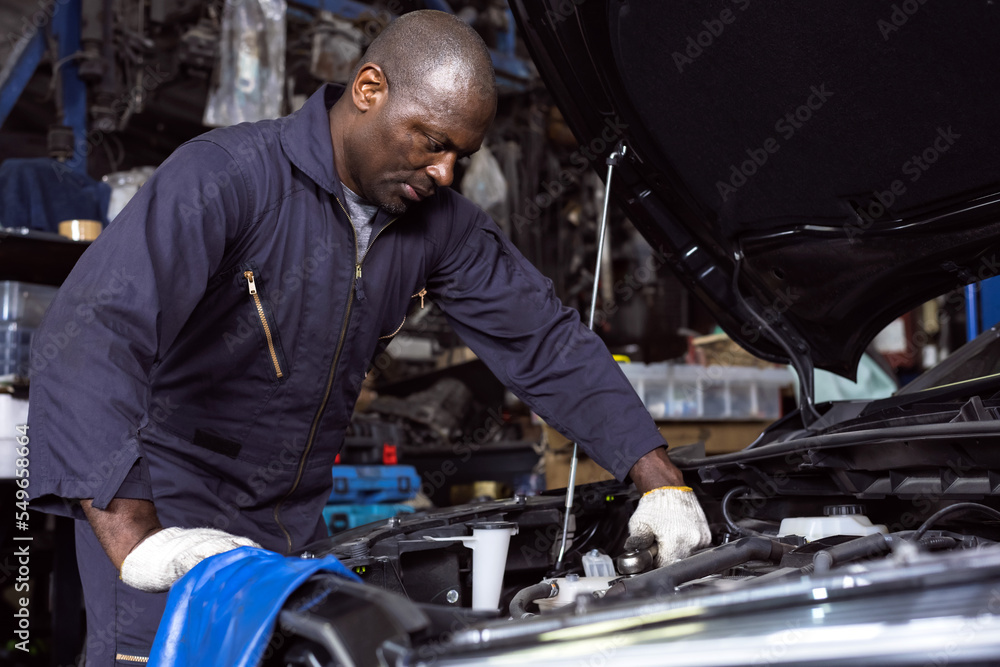 Black mechanic man fixing car in auto repair shop, Car Mechanic Concept Black mechanic man fixing car in auto repair shop, Car Mechanic Concept