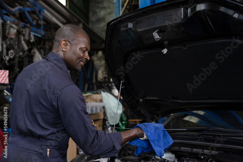 Black mechanic man working in auto repair shop, Car Mechanic Concept