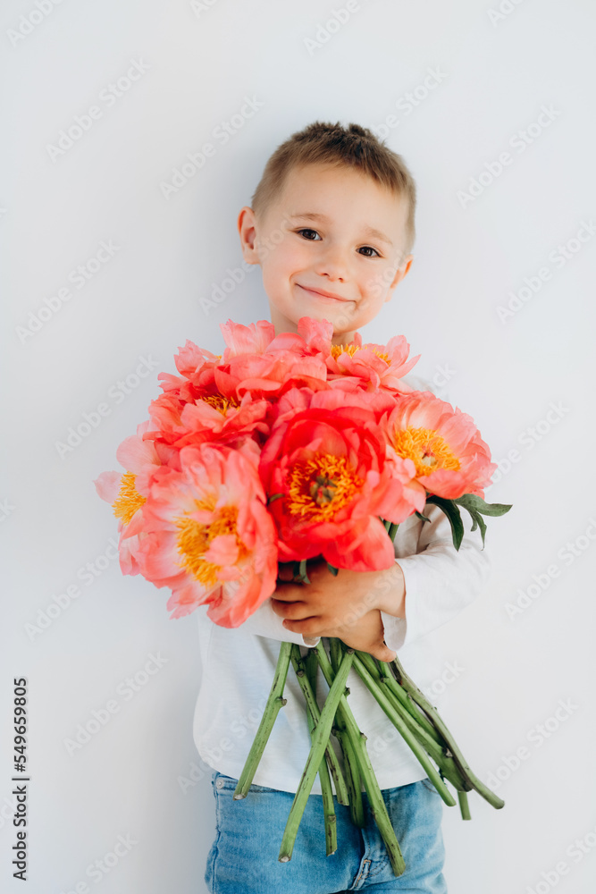 ?heerful boy with a bouquet of beautiful peonies on a white background ?heerful boy with a bouquet of beautiful peonies on a white background