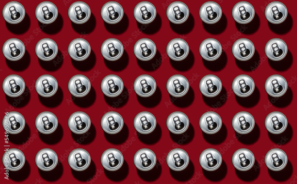 Pattern of rows of drink cans standing against red background Pattern of rows of drink cans standing against red background