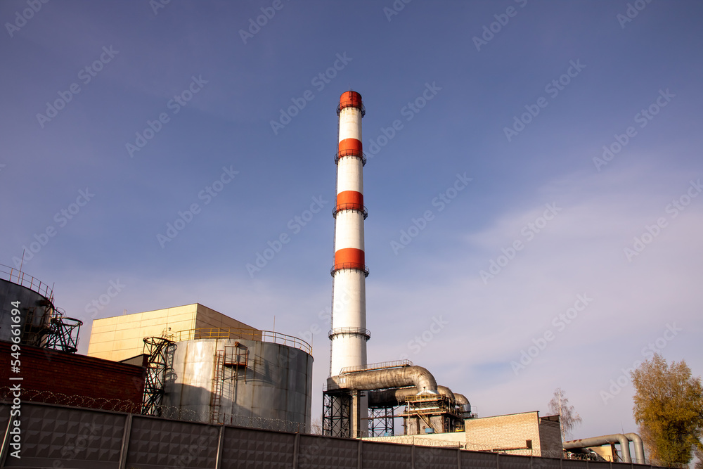 Red and white pipe of plant against background of blue sky Red and white pipe of plant against background of blue sky