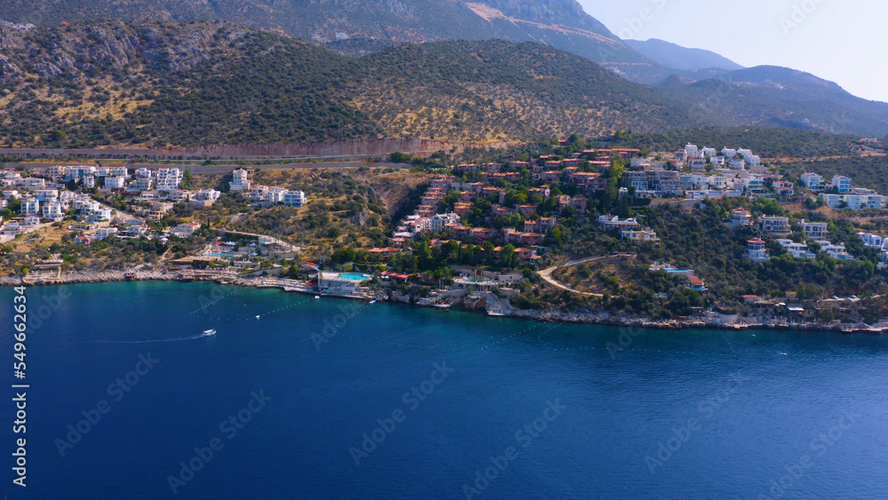 Cityscape of coastal town on the background of mountains. Aerial panoramic view from drone. Travel concept.