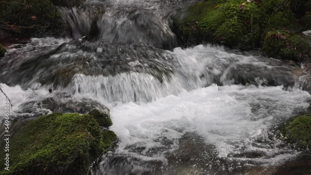 agua cristalina de montaña fluyendo a través de rocas con musgo verde agua cristalina de montaña fluyendo a través de rocas con musgo verde