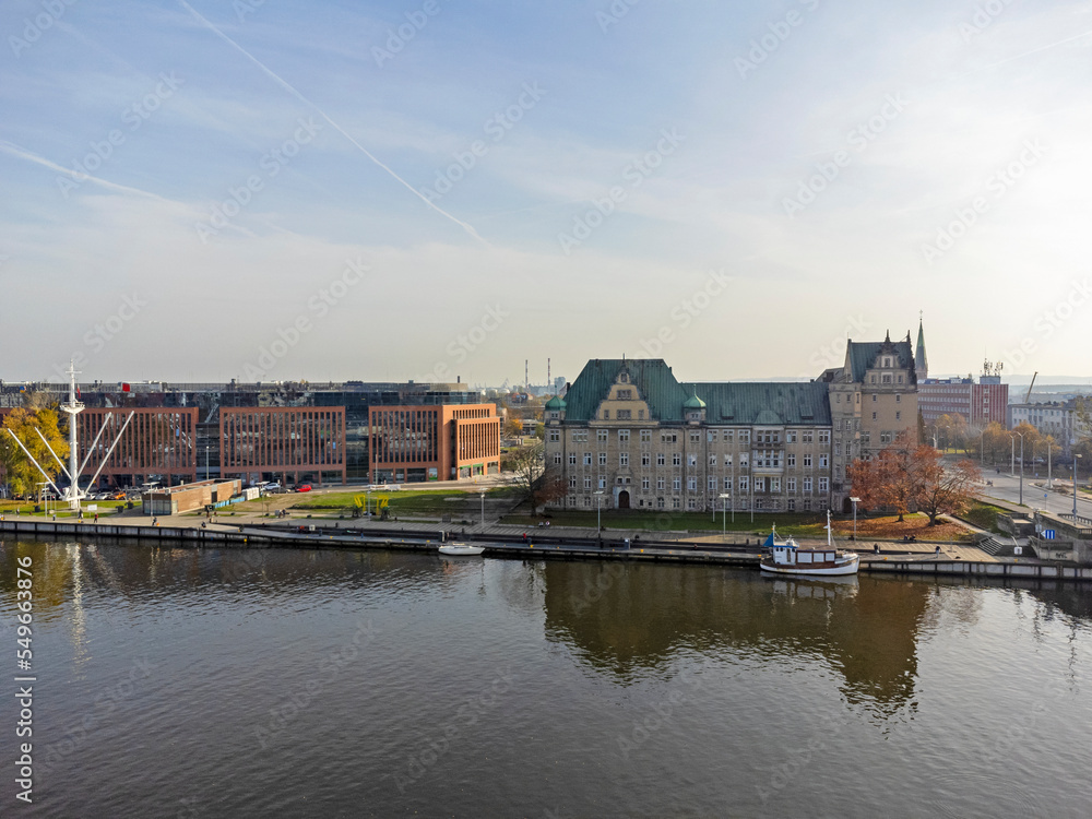 Aerial photo overlooking the Szczecin City taken on a beautiful part cloudy day in Poland showing the canal whit water, high rise buildings and local businesses and hotels.