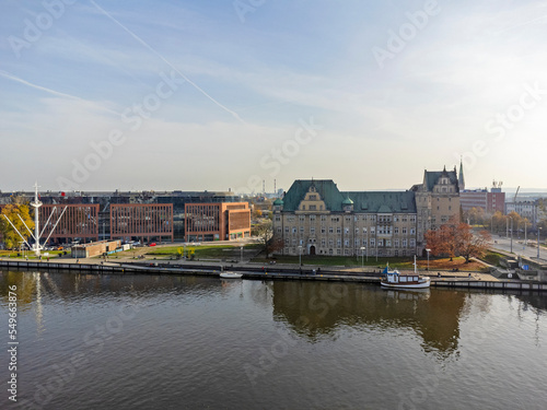 Aerial photo overlooking the Szczecin City taken on a beautiful part cloudy day in Poland showing the canal whit water, high rise buildings and local businesses and hotels.