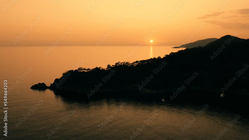 Fototapeta premium Seaside of evening landscape. Beautiful mountains and sea under sunset sky. Panoramic view from drone.
