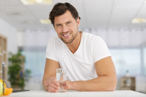 handsome man drinking water in office