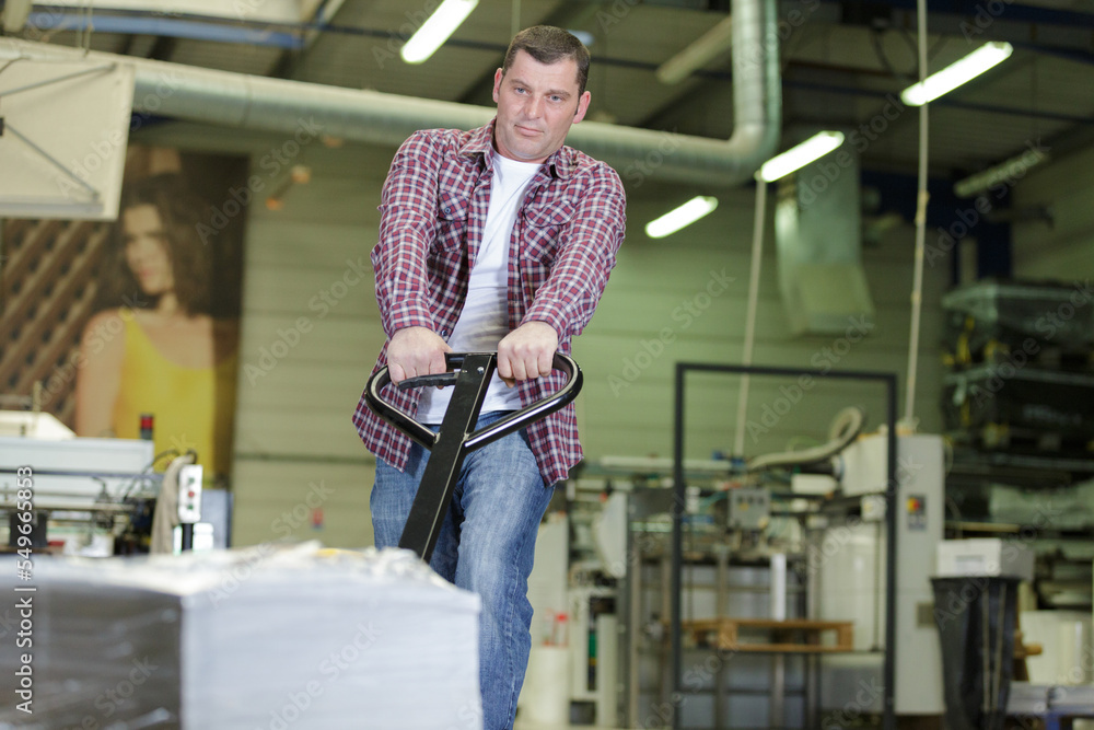 man carries heavy bags of finished products in a factory