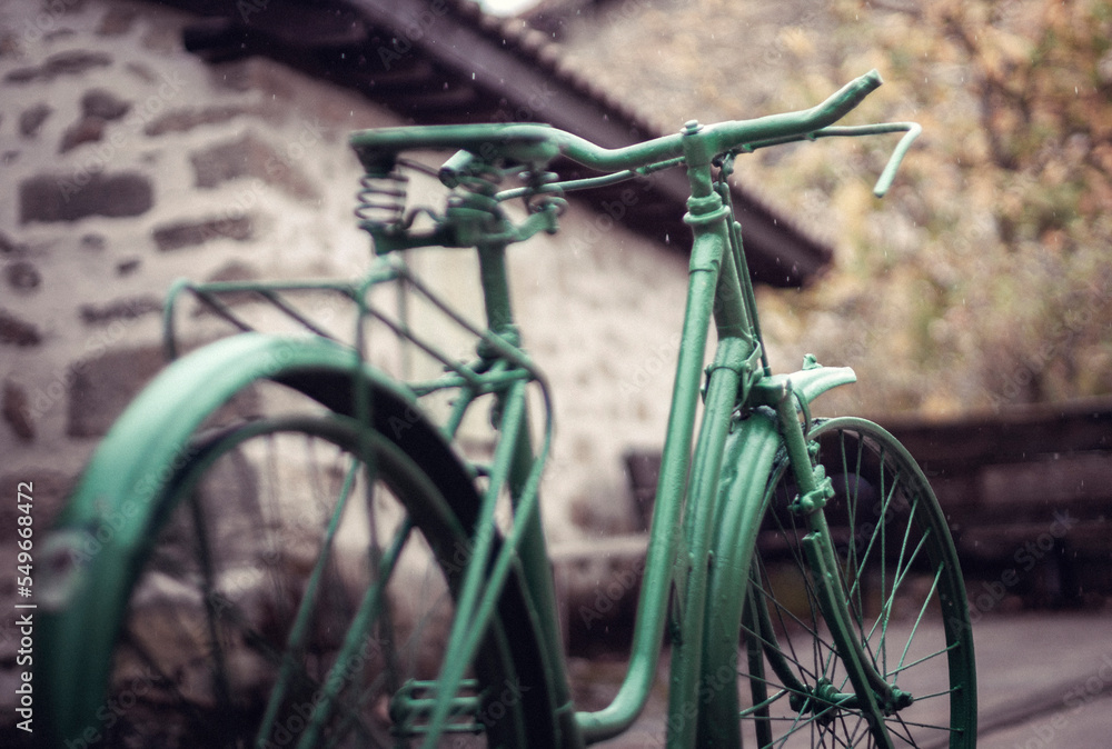 Naklejka premium Sculpture of a green painted bicycle in the rain, Erriberabeitia, Araba, Basque Country, Spain