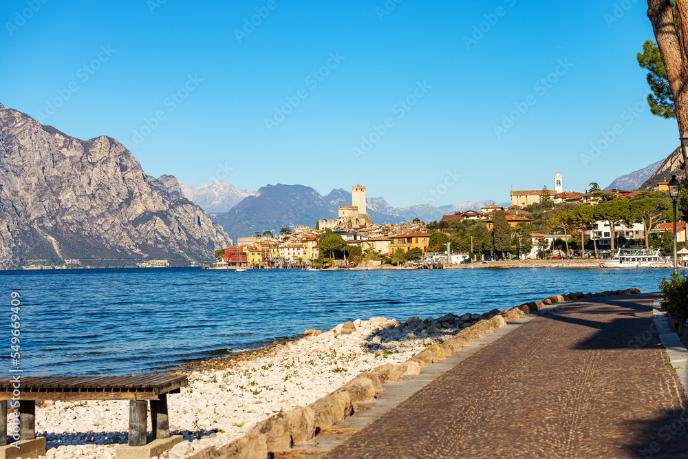 Lake Garda (Lago di Garda) and the small Malcesine village with the castle. Verona province, Italy, Veneto, southern Europe. On background the coast of the Lombardy and Trentino-Alto Adige.