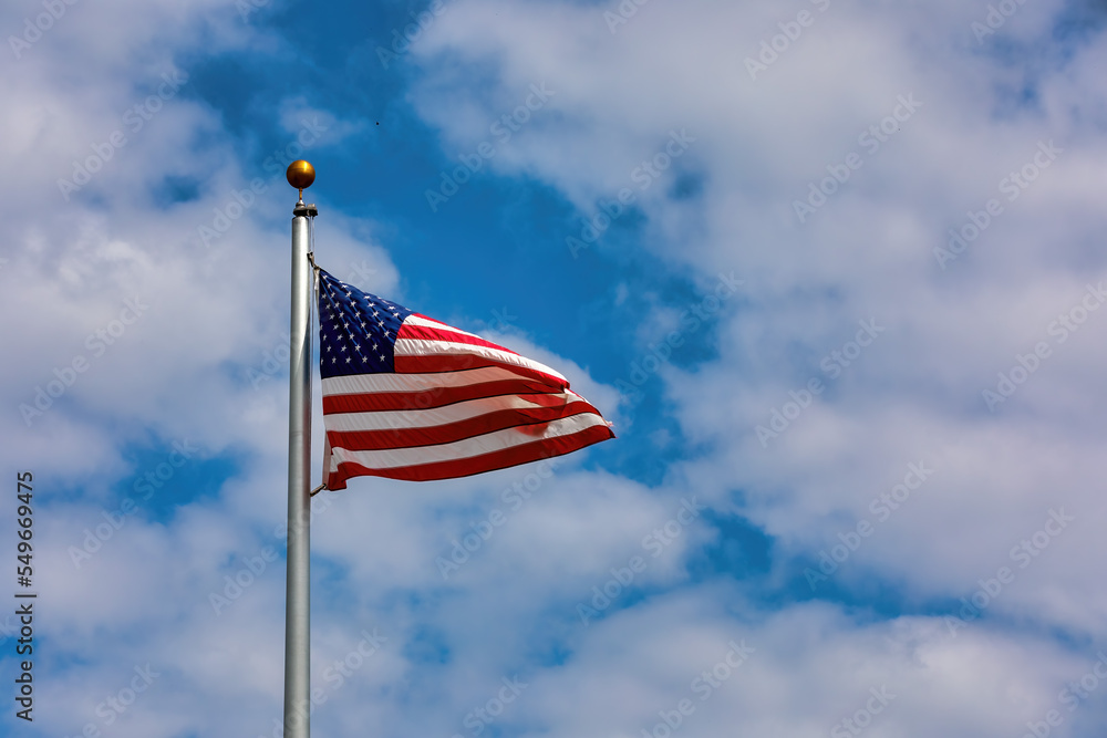 American Flag on a flagpole flying in the wind American Flag on a flagpole flying in the wind