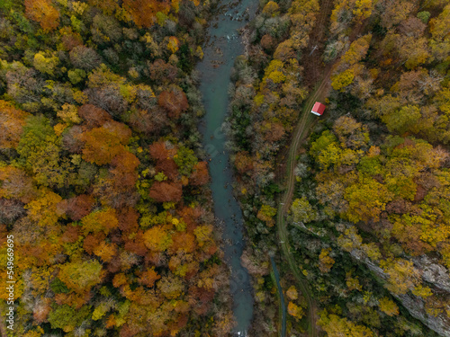 Casa al lado del rio en un bosque en otoño vista aérea photo