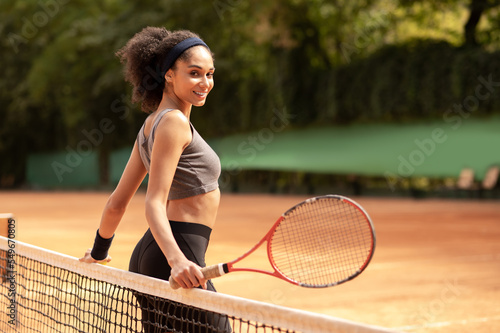 Cute dark-haired girl having a workout at the tennis court © zinkevych
