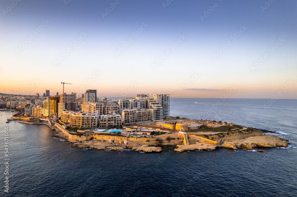 Aerial view of Sliema in Malta, skyline at sunset, blue sea waters and sky. Aerial drone view