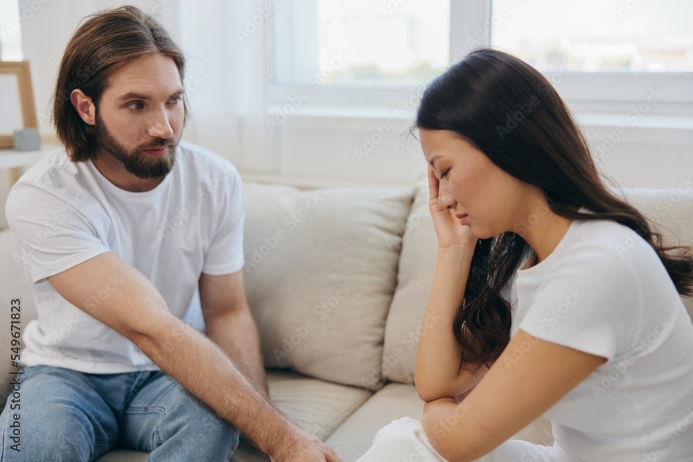 An Asian woman is sad and crying with her male friend at home. Stress and misunderstanding in a relationship between two people and supporting each other's mental and emotional well-being An Asian woman is sad and crying with her male friend at home. Stress and misunderstanding in a relationship between two people and supporting each other's mental and emotional well-being