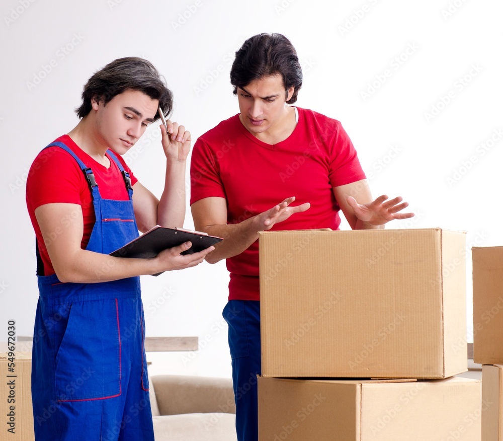 Two young contractor employees moving personal belongings Two young contractor employees moving personal belongings