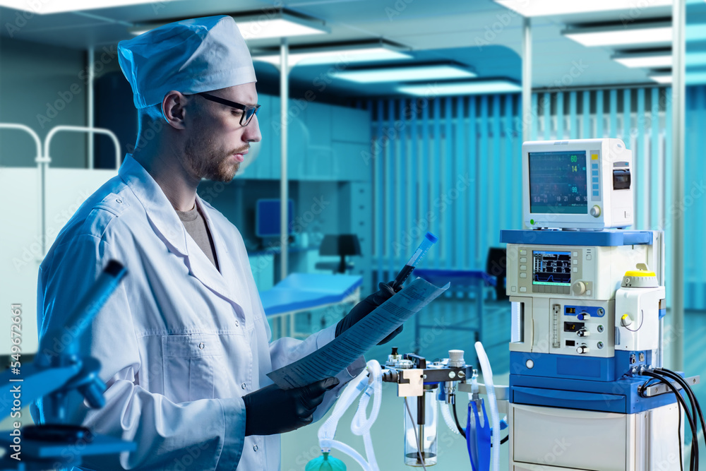 Naklejka premium Man doctor. Employee of clinic holds test tube with blood. Nurse in anesthesiologists office. Medical lab worker. Doctor stands in interior of hospital. Doctor man near anesthesia equipment