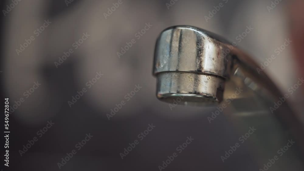 Strong pressure of the water jet from the kitchen or bathroom faucet. Person turns on the tap. Home equipment to maintain cleanliness. Strong pressure of the water jet from the kitchen or bathroom faucet. Person turns on the tap. Home equipment to maintain cleanliness.