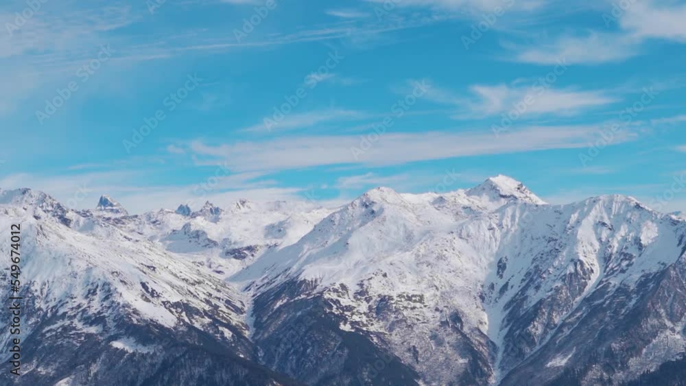 Snow covered Himalayan mountain peaks in front of blue sky with clouds at Manali in Himachal Pradesh, India. Winter landscape with snow capped mountain under sunlight. Snowy winter background. Snow covered Himalayan mountain peaks in front of blue sky with clouds at Manali in Himachal Pradesh, India. Winter landscape with snow capped mountain under sunlight. Snowy winter background.