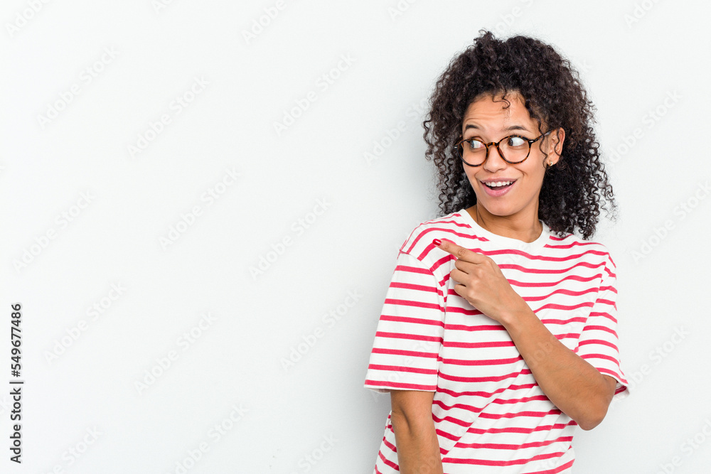 Young african american woman isolated points with thumb finger away, laughing and carefree. Young african american woman isolated points with thumb finger away, laughing and carefree.