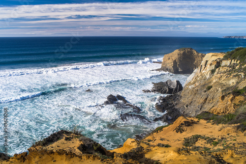 spectacular cliffs, sharp rocks, wild beaches and big waves on the Algarve coast. Ocean View. Horizontal, daylight