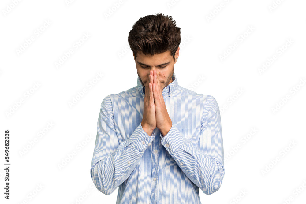 Young caucasian handsome man isolated praying, showing devotion, religious person looking for divine inspiration. Young caucasian handsome man isolated praying, showing devotion, religious person looking for divine inspiration.