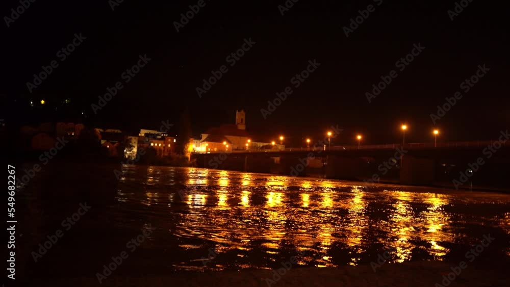 River flowing at night with city lights from bridge reflected on water in Passau Germany River flowing at night with city lights from bridge reflected on water in Passau Germany