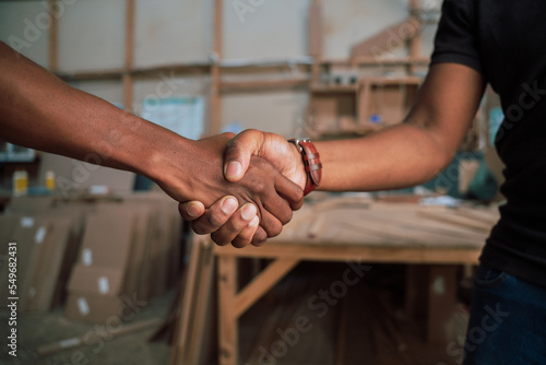 Adult men shacking hands in business workshop