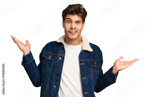 Foto Young caucasian handsome man isolated confused and doubtful shrugging shoulders to hold a copy space