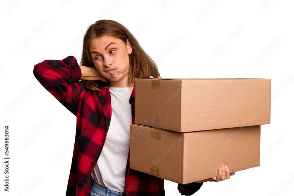 Young caucasian woman moving while picking up a box full of things isolated touching back of head, thinking and making a choice. Young caucasian woman moving while picking up a box full of things isolated touching back of head, thinking and making a choice.