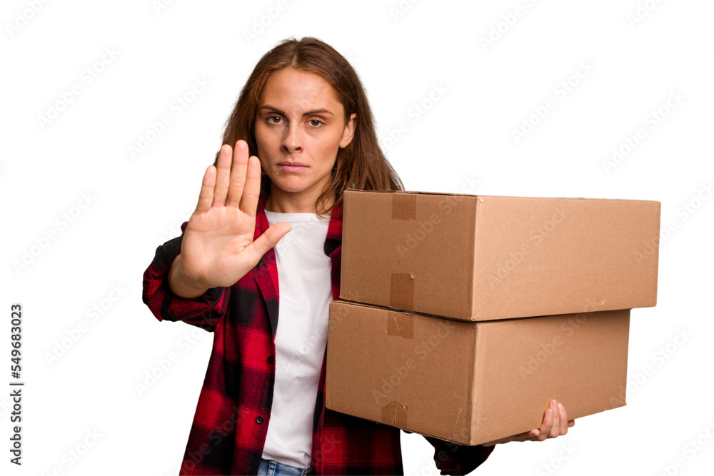 Young caucasian woman moving while picking up a box full of things isolated standing with outstretched hand showing stop sign, preventing you. Young caucasian woman moving while picking up a box full of things isolated standing with outstretched hand showing stop sign, preventing you.
