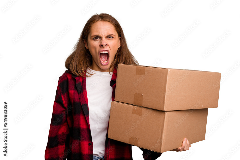 Young caucasian woman moving while picking up a box full of things isolated screaming very angry and aggressive. Young caucasian woman moving while picking up a box full of things isolated screaming very angry and aggressive.
