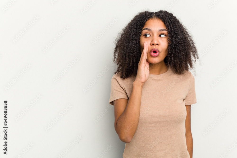 Young african american woman isolated on white background is saying a secret hot braking news and looking aside Young african american woman isolated on white background is saying a secret hot braking news and looking aside