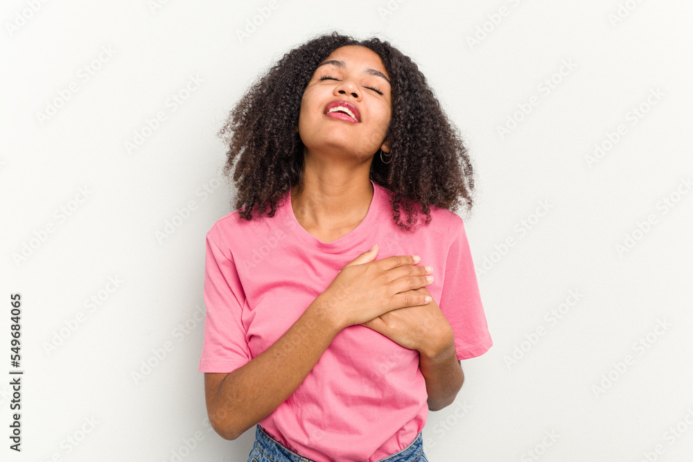 Young african american woman isolated on white background has friendly expression, pressing palm to chest. Love concept. Young african american woman isolated on white background has friendly expression, pressing palm to chest. Love concept.