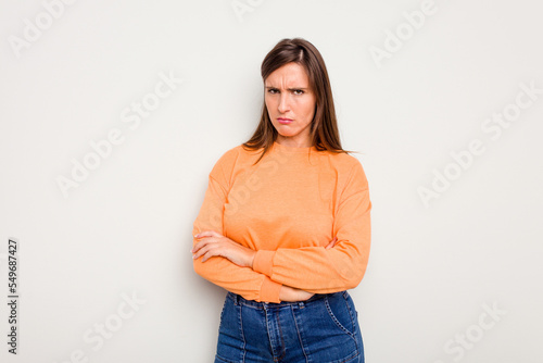Young caucasian cute woman isolated on white background frowning face in displeasure, keeps arms folded. © Asier