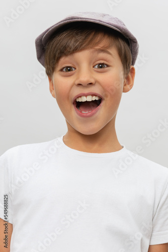 Emotional portrait of caucasian teen boy wearing white t-shirt. Surprised teenager looking at camera. Handsome happy child, isolated on white background.