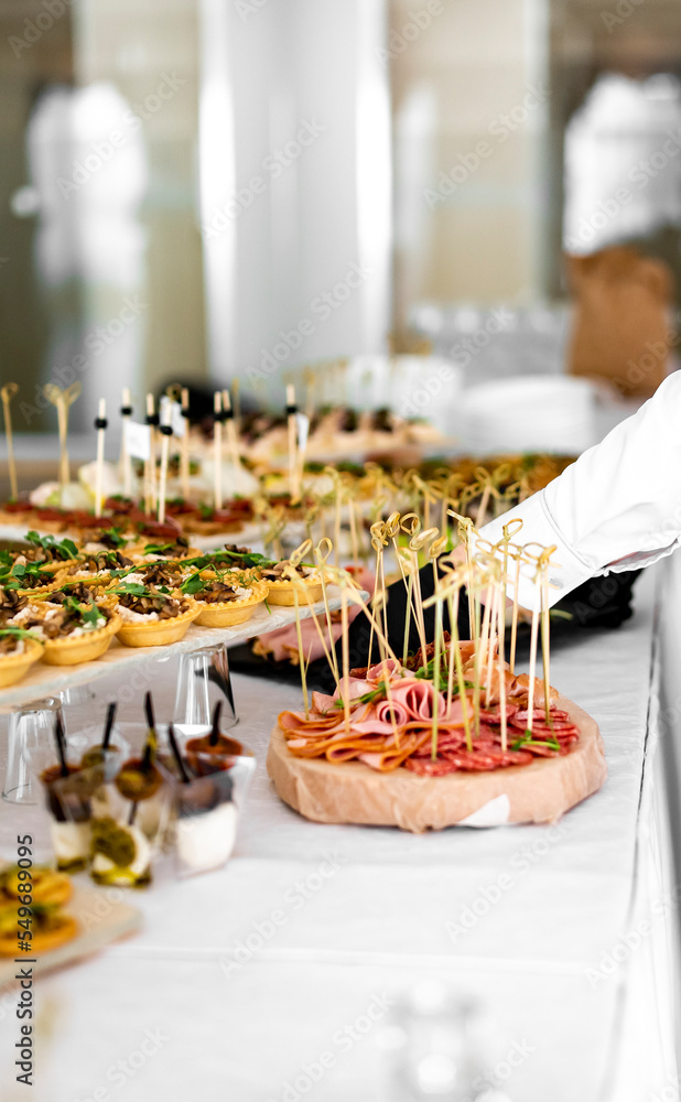 waiter prepare food for a buffet table in a restaurant. catering