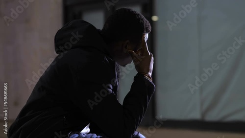 Wallpaper Mural despair, anguish - sad depressed black man in the city at night thinking Torontodigital.ca