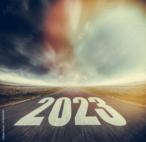 2023 written on highway road in the middle of asphalt road and dark cloudy sky. Future vision 2023