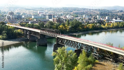 Delightful Aerial Shot approaching the Red Bridge of the South Thompson River in Kamloops , Okanagan British Columbia with foggy downtown on a overcast day photo