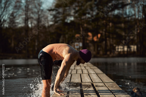 Foto Caucasian adult man going out of frozen lake in the winter