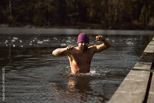 Foto Caucasian adult man going out of frozen lake in the winter